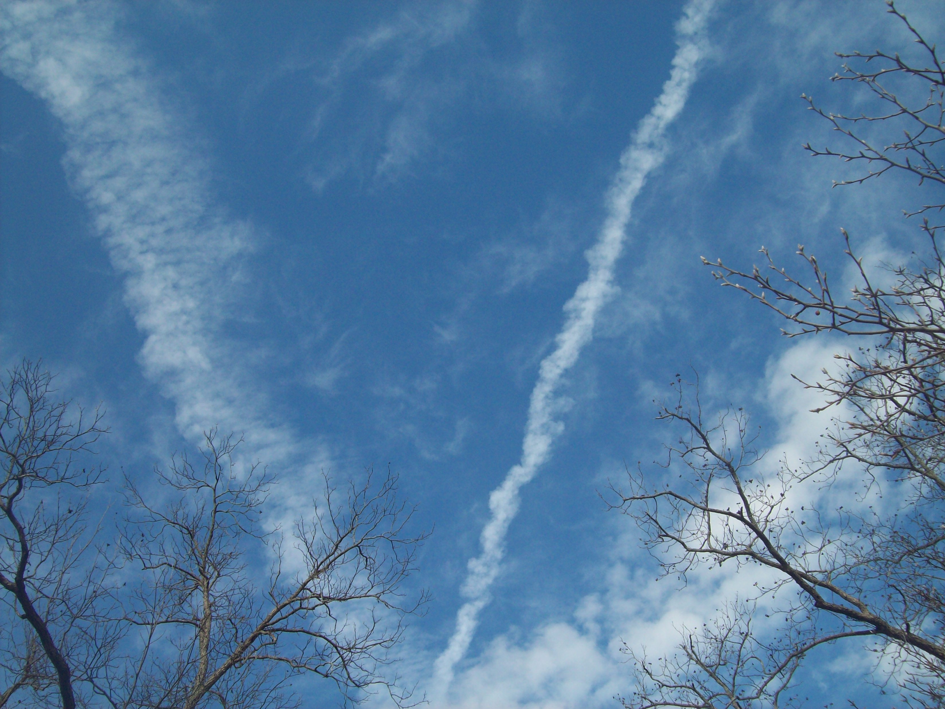 Chemtrails across crystal-clear blue skies